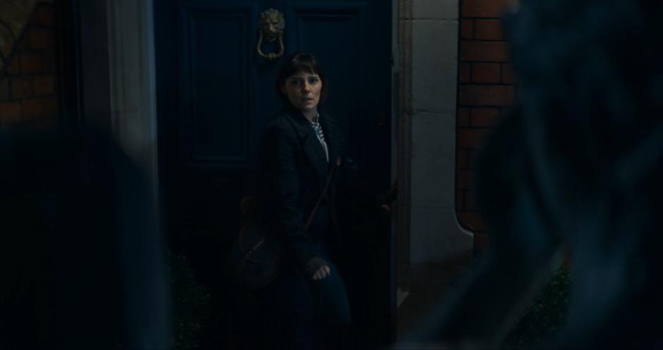 Claire kneels down to pick up her keys while keeping her eyes on the Weeping Angel.