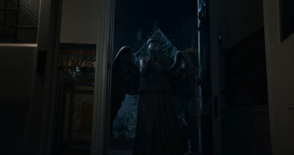 The Weeping Angel stands in the doorway after zapping away Claire.