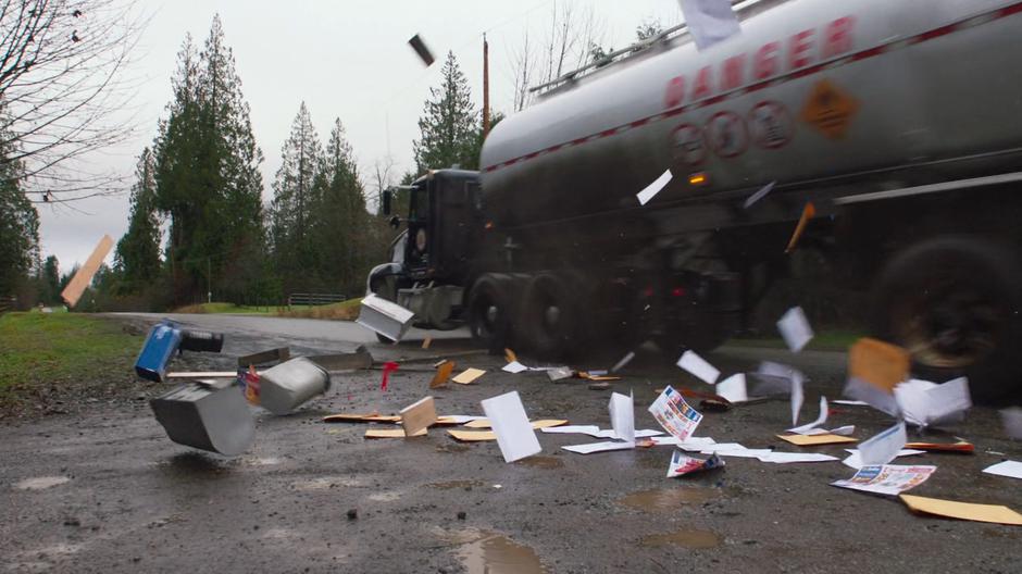 Mail flies everywhere when the truck smashes through the boxes.