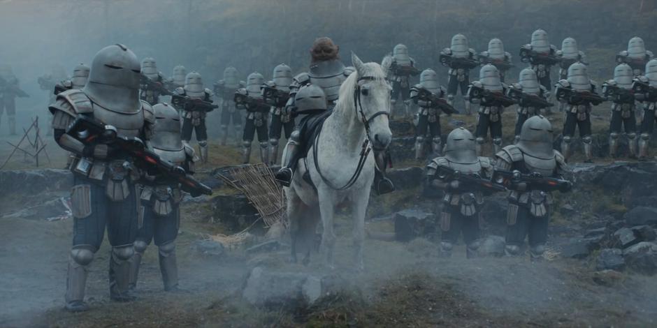 Skaaak rides up on a horse surrounded by their troops.