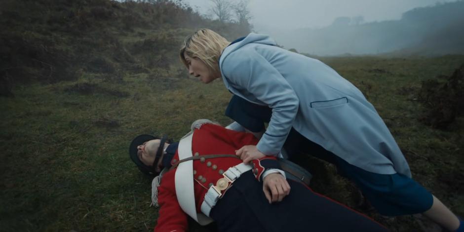 The Doctor kneels down over her soldier escort whom she knocked out.