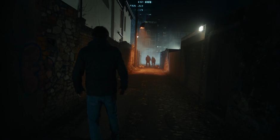Dan looks down to the alley where two people have knocked out the Sontarans chasing him.