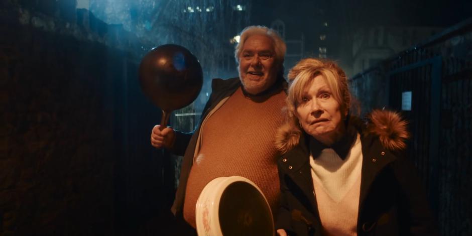 Dan's parents look at him from down the alley while holding a wok and a frying pan.