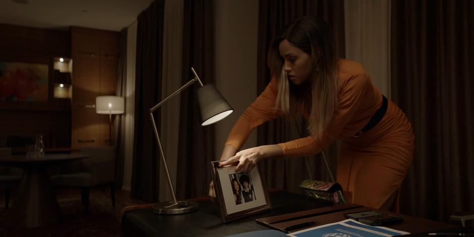 Sophie puts back the framed photo of Jada and Marquis on the desk.