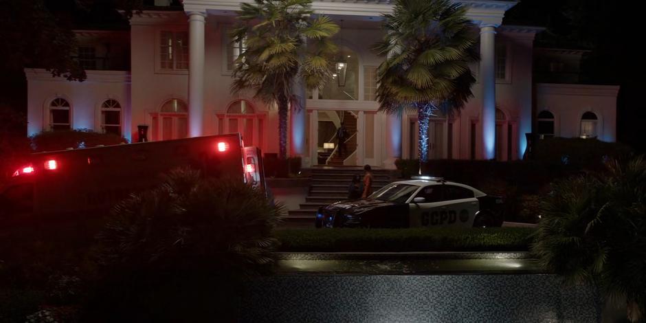 Sophie approaches Ryan who is sitting on the steps of the mansion with a blanket around her shoulders as an ambulance and police car sit out front.