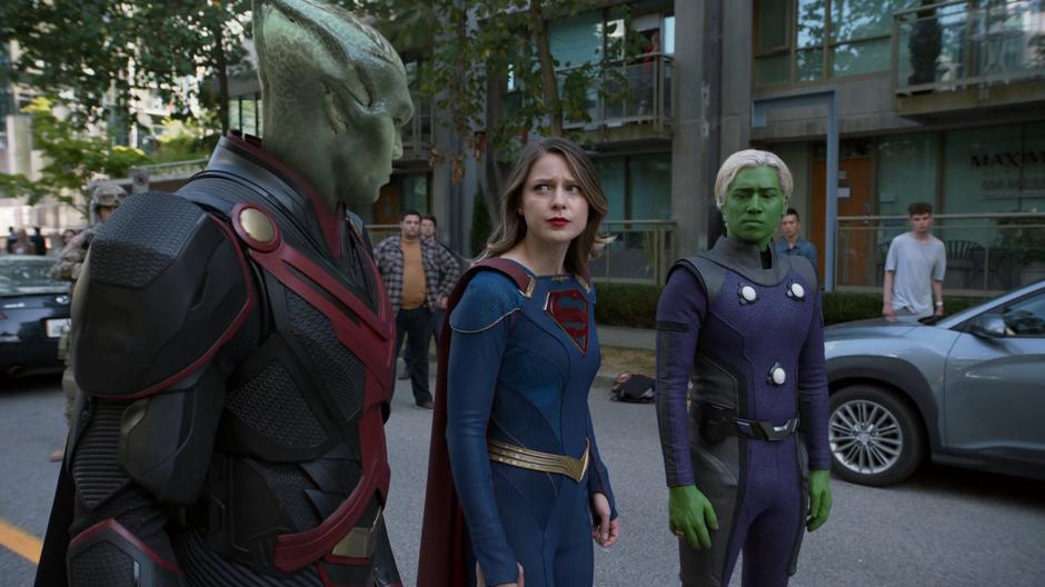 J'onn, Kara, and Brainy share looks before flying off.