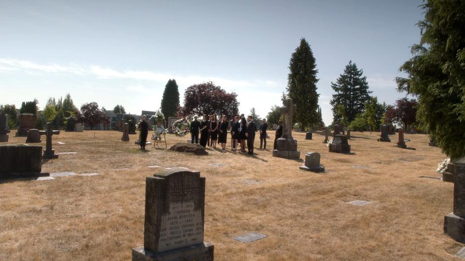 The Super Friends stand at William's grave during his funeral.
