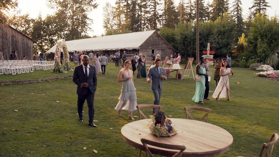 James, Kara, and Winn walk to a table away from the group to chat.