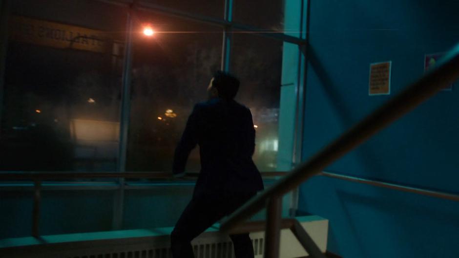 Kenny stands in the stairwell look up at the meteor approaching the school.