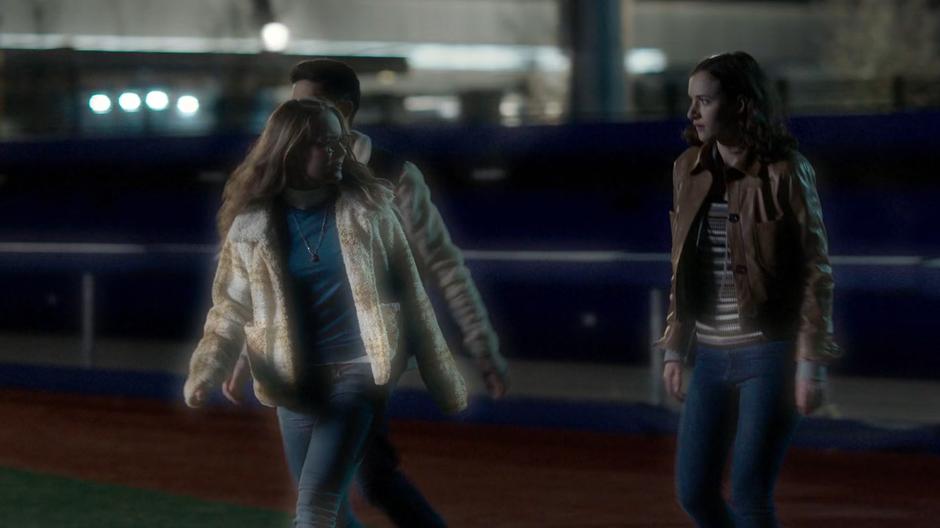 Kenny, Kara, and Alex walk across a field in Nia's dream.