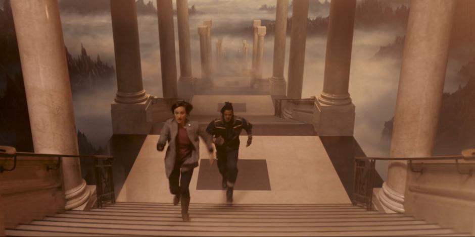 Diane and Vinder race to the top of the stairs to reach the TARDIS.