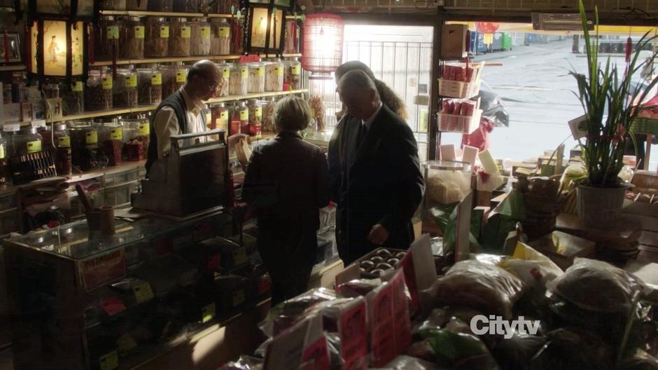 The team interviews the store owner about Johnny McKee.