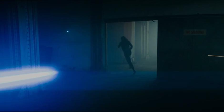 Sarah races through the basement as a Dalek fires at her.