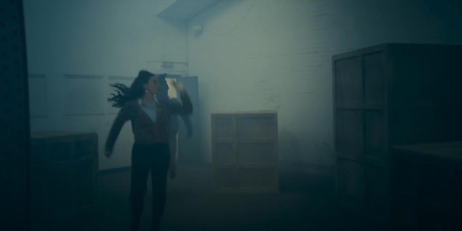 Sarah and Nick run through the basement towards the loading dock door.