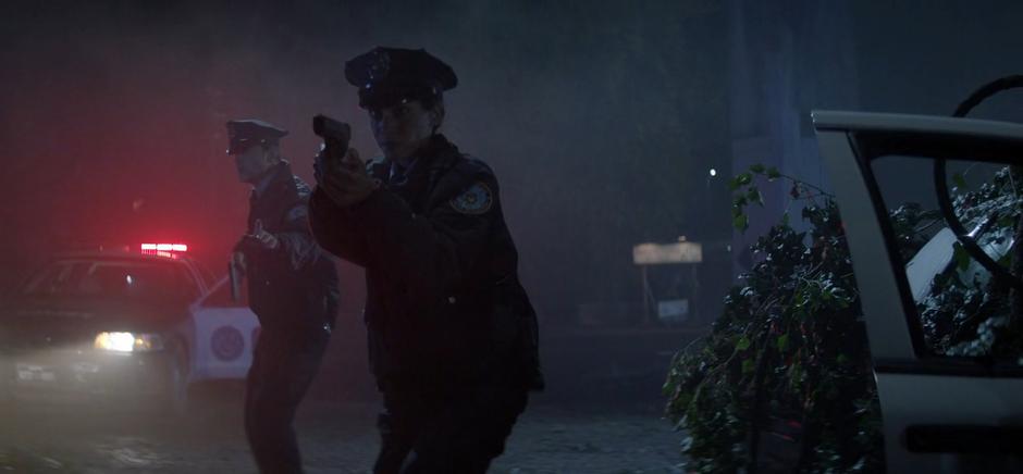 Renee and her partner draw their guns after finding another police car filled with plants.