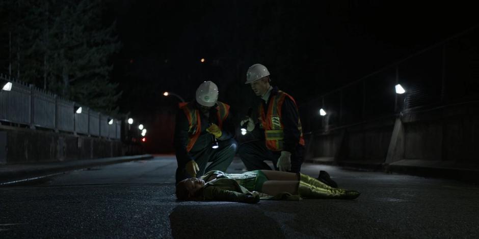 Two workers find Mary unconcious on the top of the dam.