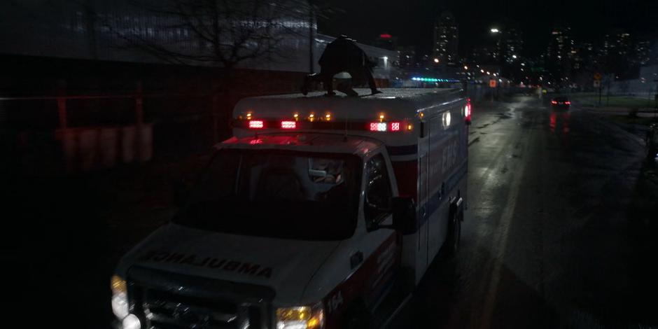 Ryan climbs on the roof of the ambulance as it speeds down the street.