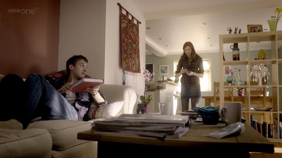 Amy opens the Doctor's note while Rory looks through the history book.