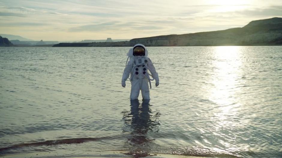 The astronaut emerges from the lake.