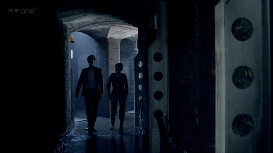 The Doctor and Cleaves walk down one of the tunnels.