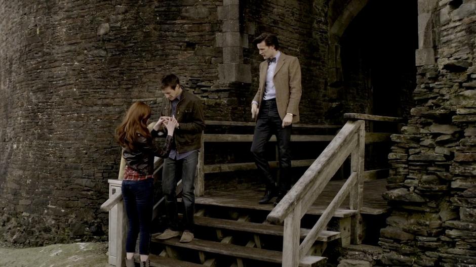 Amy checks on Rory's hand after he touched some spilled acid.