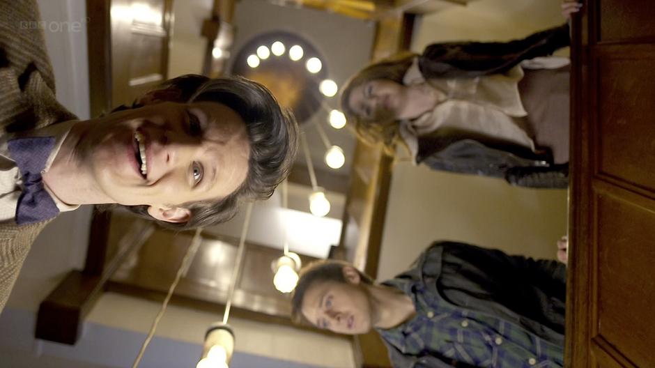 Amy, Rory, and the Doctor look down the hotel staircase.