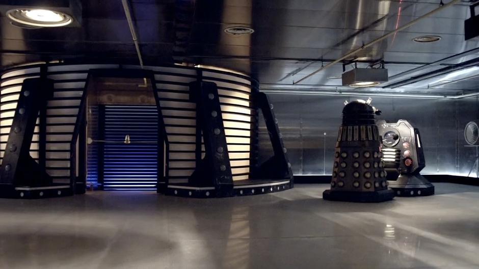 A Dalek fiddles with a control panel.
