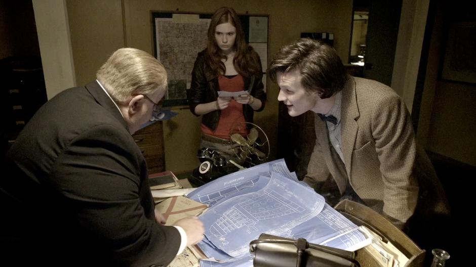Churchill, Amy, and the Doctor go over the Dalek plans.