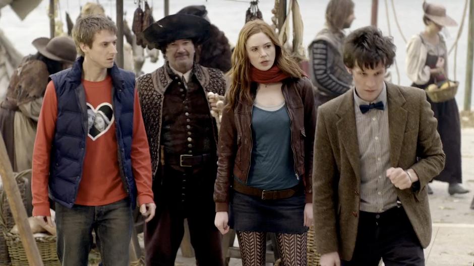 Amy, Rory, and the Doctor walk through the crowd.