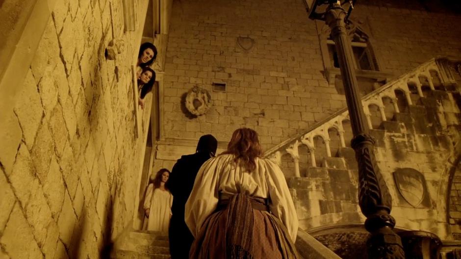 Amy walks up the stairs while the vampire girls look on.