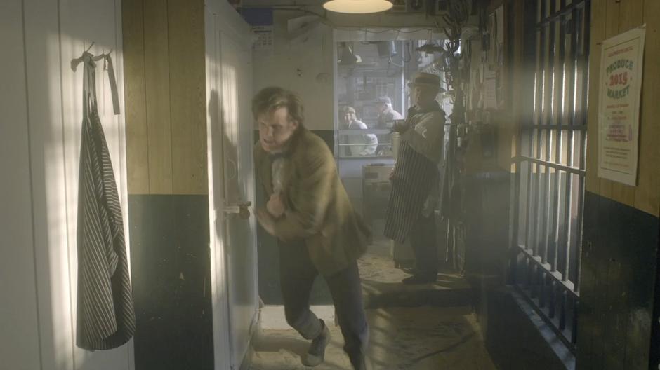 The Doctor stumbles towards the freezer while old people break in through the shop door.