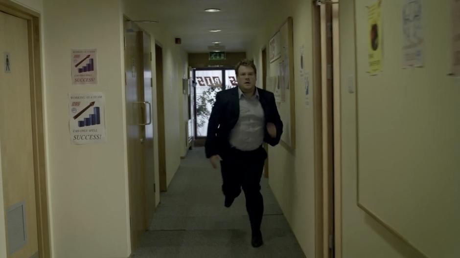 Craig runs through the hall to his office because he is very late.