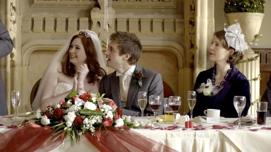 Amy and Rory listen to her father's amusing toast.