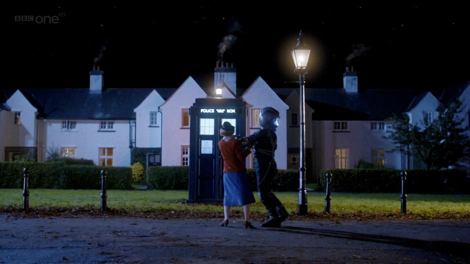 Madge attempts to maneuver the Doctor back to the TARDIS.