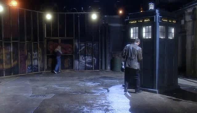 The Doctor unlocks the TARDIS while Rose tries to get through the gate at the end of the alley.