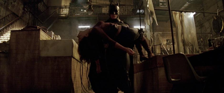 Batman carries Rachel Dawes away after she was drugged by The Scarecrow.