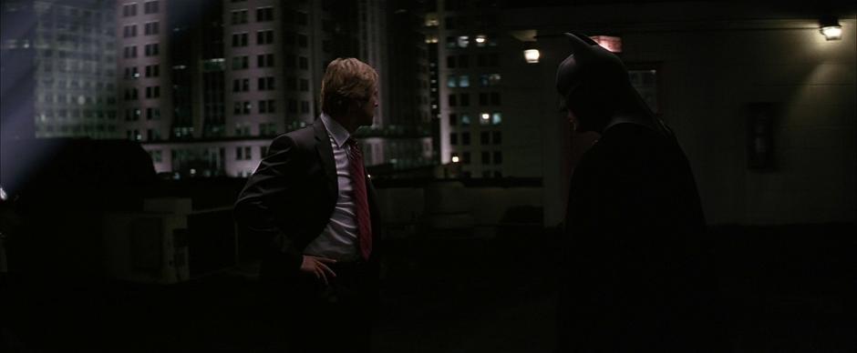 Jim Gordon runs to the rooftop to find Harvey Dent using the Batsignal.