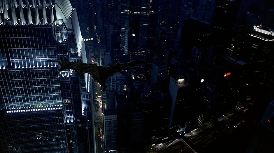 Batman flys towards Lau's office building.