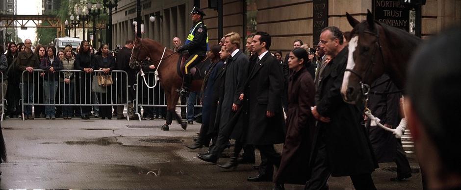 The Mayor and Harvey Dent walk at the front of the funeral procession.