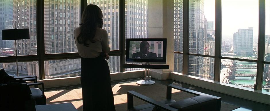 Rachel Dawes watches Harvey Dent claim to be Batman on the news.