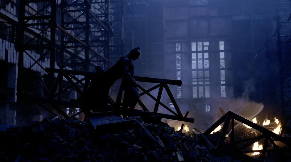 Batman stands in the ruins of the warehouse where Rachel Dawes was killed.
