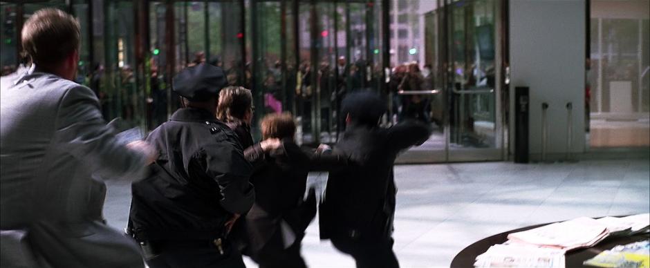 A man fires upon Reese and his escort.