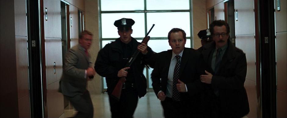 Jim Gordon escorts Reese through the lobby.