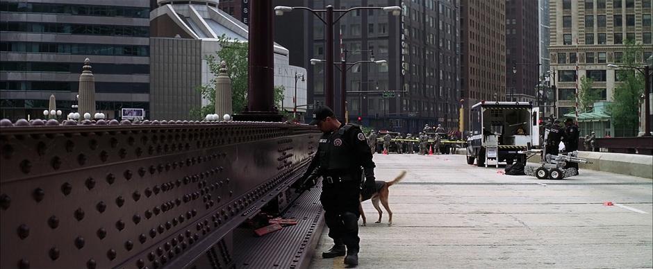 A bomb squad officer searches the bridge for devices.