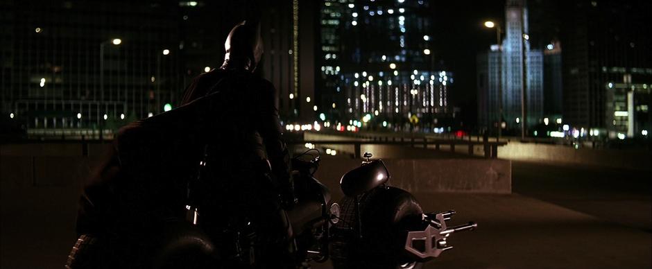 Batman sits on his bike listening to the cell signals.
