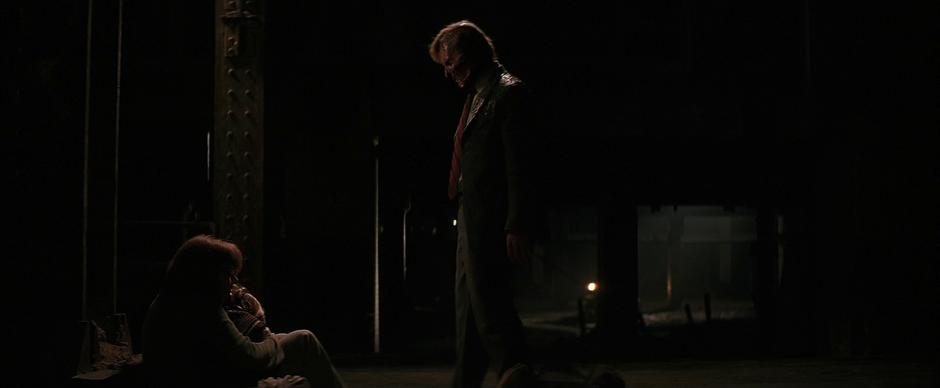 Harvey Dent stands over Jim Gordon's family.