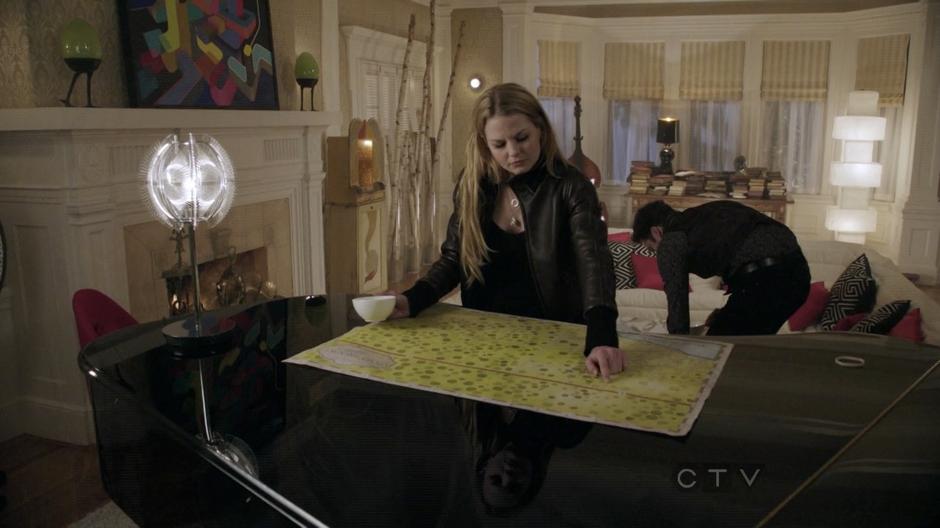 Emma looks at the map provided by Jefferson in his living room.