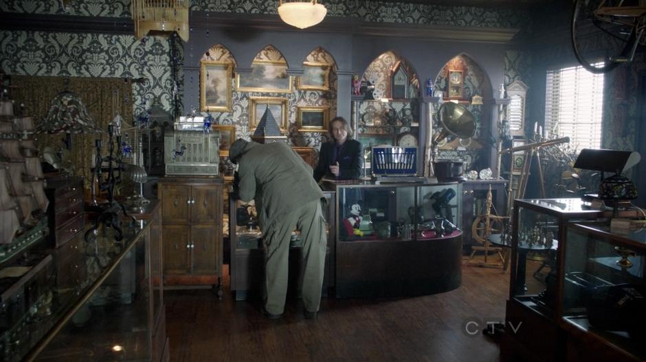 Mr. Gold tells August to wait while Geppetto examines the cuckoo clock.