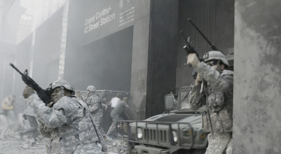 Soldiers help civilians escape into the subway station.