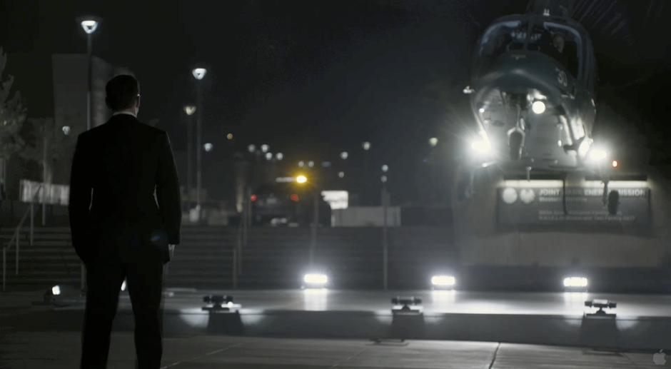 Agent Coulson waits for Nick Fury's helicopter to land.